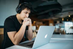 Guy with headphones on laptop