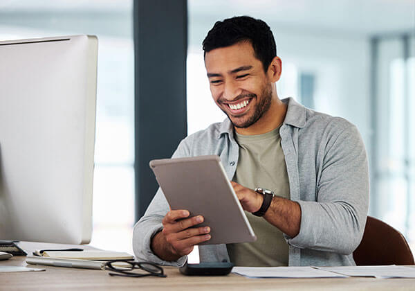 Happy businessman using his tablet